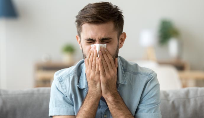 Person sneezing due to allergic effect Person sneezing due to allergic effect