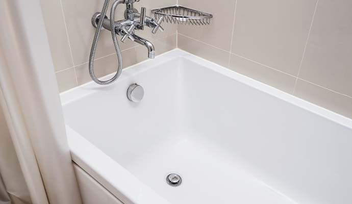 A clean white bathtub in a bathroom