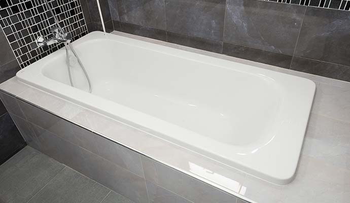 A clean white bathtub in a bathroom