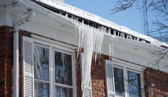Heavy snow and ice damaged house roof