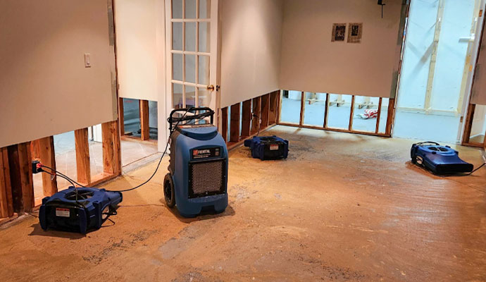 Commercial dehumidifier and air movers drying water damaged room