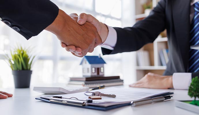 Handshake between two professionals in business suits over a table