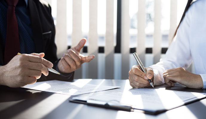 Insurance adjuster reviewing claim paperwork with client